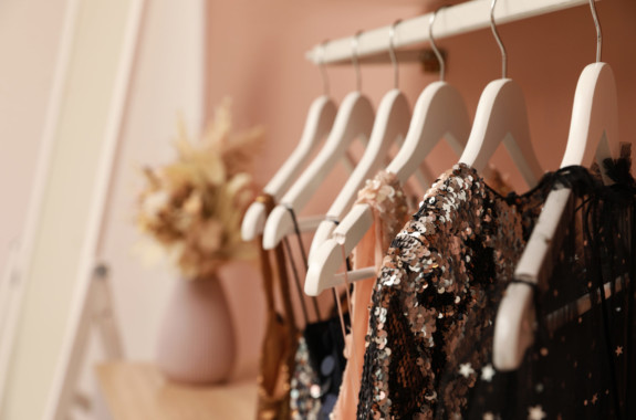 Collection of trendy women's garments on rack indoors, closeup and space for text. Clothing rental service