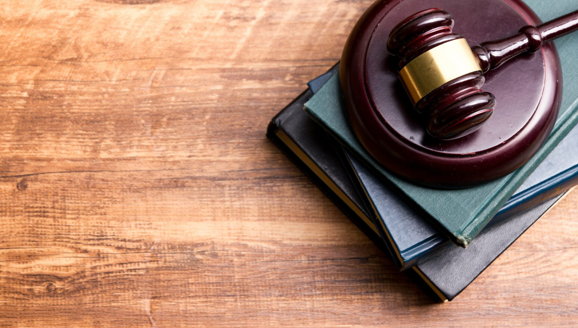 Legal Law concept - Open law book with a wooden judges gavel on table in a courtroom or law enforcement office. Copy space for text.