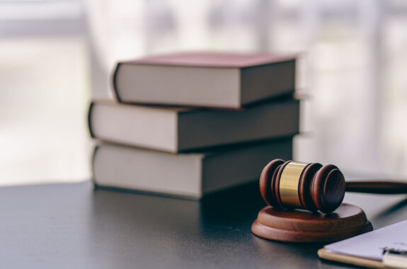 Lawyer or judge's hammer in court The auction hammer is on the woo table. Legal subject or auction company with book sign in office