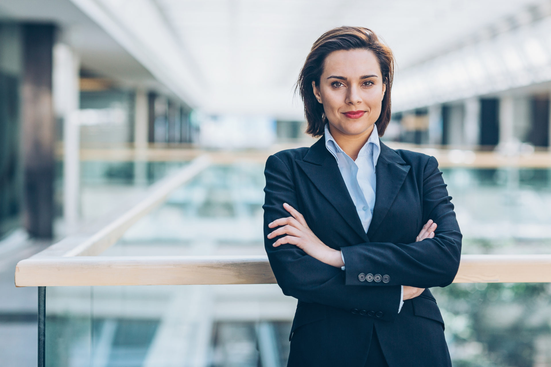 Young woman in business wear standing with armes crossed in business environment